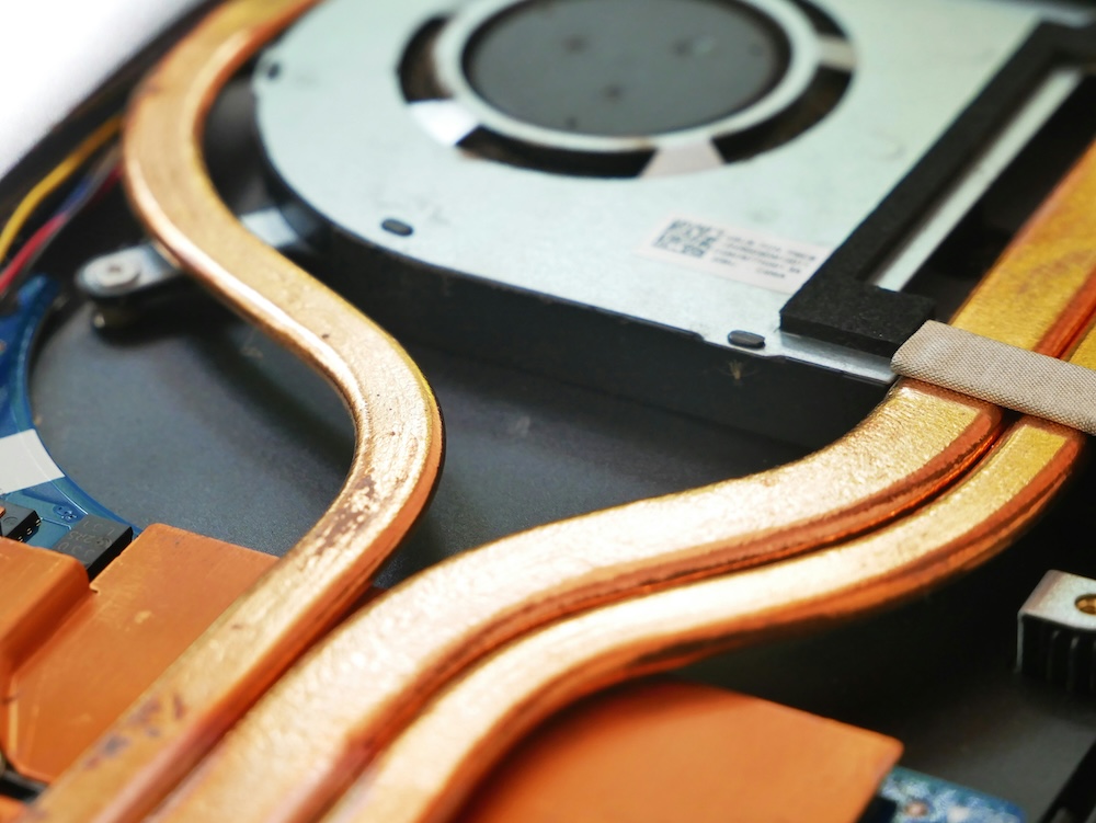 A close up of flat copper pipes leading to an electrical item. 