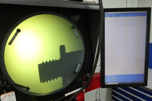 Close-up of a FANUC Series 0i-TF CNC control panel displaying machining program data and coordinates at Sheldon Precision.
