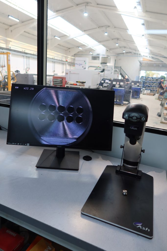 Optical comparator in Sheldon Precision's quality control room measuring a threaded precision component.